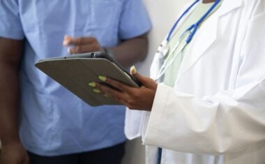 California medical assistant shows paperwork to coworker
