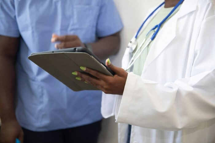 California medical assistant shows paperwork to coworker